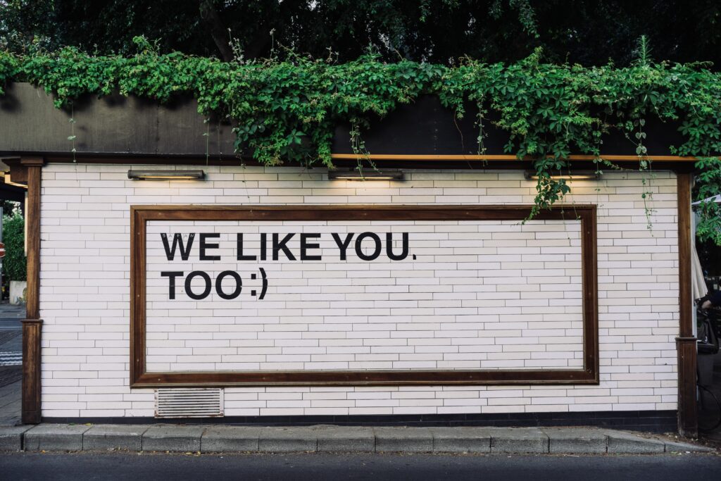 A white wall with We Like You, Too statement